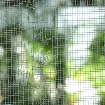 A close up of a torn window screen