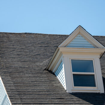 A closeup of a home's roof and exterior window