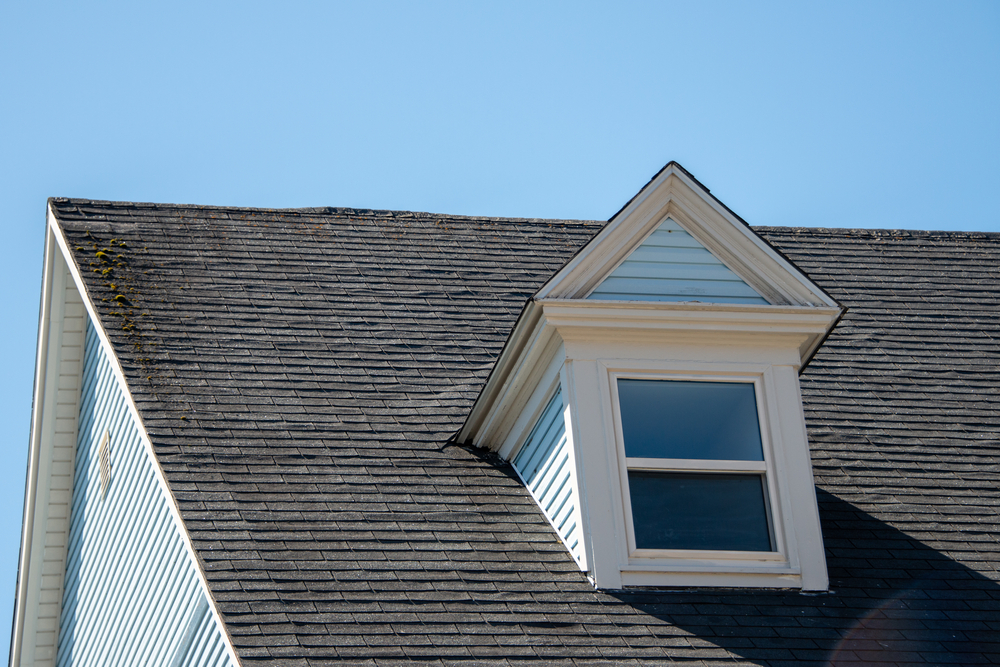 A closeup of a home's roof and exterior window